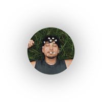 a man laying in the grass with a flower on his head