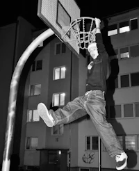 a man jumping into a basketball hoop