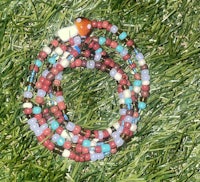 a colorful beaded necklace laying on the grass