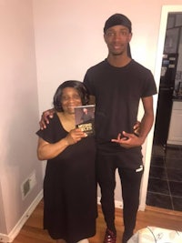 a man and woman standing next to each other holding a cd