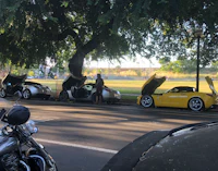 a motorcycle parked next to a yellow sports car