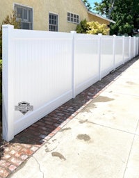 a white vinyl fence in front of a house