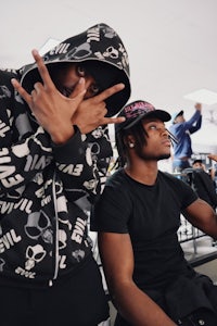 two men in black hoodies posing for a picture