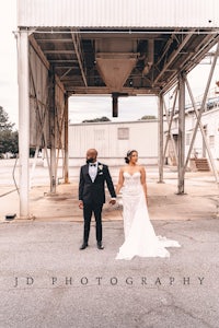 a bride and groom standing in front of an industrial building