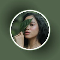 a woman with a green leaf on her face