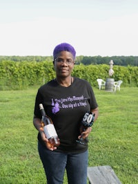 a woman holding a bottle of wine and a t - shirt