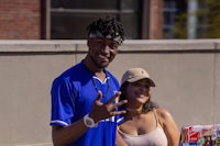 a man in a blue shirt is standing next to a woman