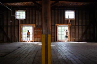 two people standing in a room with windows