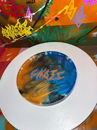 a blue and orange plate with graffiti on it