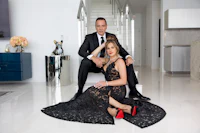 a man and woman posing in front of a staircase