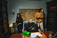 three people sitting at a desk in an office