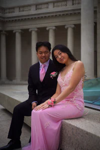 a man and a woman in formal attire posing for a photo