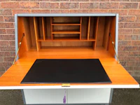 a wooden desk with a desk top and drawers