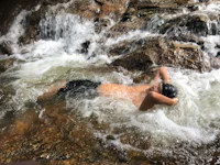 a man is laying in the water of a river