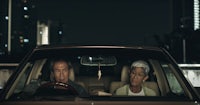 a man and woman sitting in a car at night
