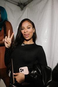 a woman is posing for a photo with a peace sign