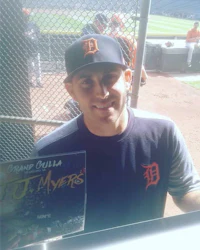 a detroit tigers player holding a book