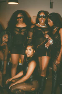 a group of women in black outfits posing for a photo