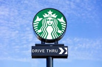 a starbucks drive thru sign is shown against a blue sky