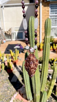 a necklace with a cactus in the background