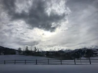 a sunny day in the mountains with clouds in the sky