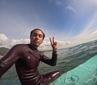 a man in a wetsuit on a surfboard