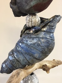 a sculpture of a bird sitting on top of a shell
