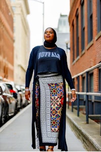 a woman wearing a hijab walking down a city street