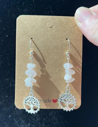 a pair of earrings with a tree of life on them