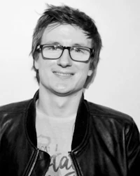 a black and white photo of a man wearing glasses and a leather jacket