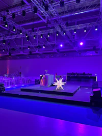 a stage set up with purple lights in the background