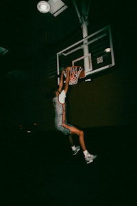 a man dunks a basketball in the dark