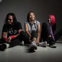 a group of women sitting on the floor in front of a camera