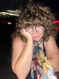 a woman wearing glasses and a tie