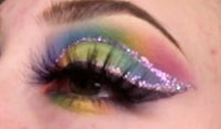 a close up of a woman's eye with colorful eye makeup