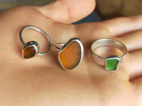 three sea glass rings on a person's hand