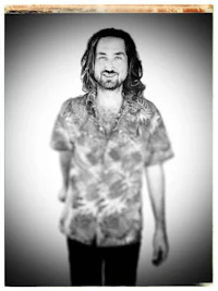 a black and white photo of a man with long hair