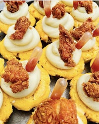 a tray of appetizers with fried chicken on top