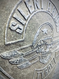 a close up of a metal plate with a skull on it
