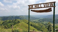 a wooden sign with the word cg hill view in the background