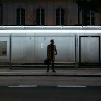 a man standing on a bus stop at night