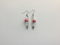 a pair of earrings with red and white beads