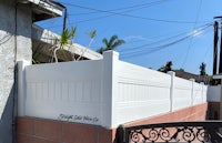 a white fence next to a house