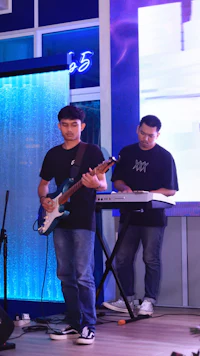 a man playing a guitar in front of a blue screen
