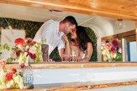 a couple kissing in front of a bar