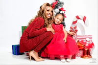 a woman in a red dress and a little girl posing for a photo