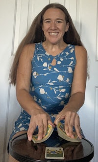 a woman sitting on a stool holding a deck of cards