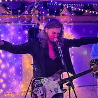a man playing guitar in front of a crowd of people