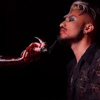 a man is holding a snake in his hand