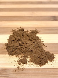 a pile of brown powder on a wooden table